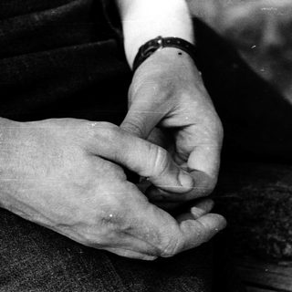 Two hands holding and examining a small object.
