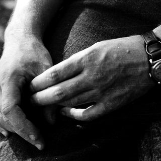 Close-up of hands clasping a wrist.