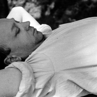 Man lying down resting outdoors.