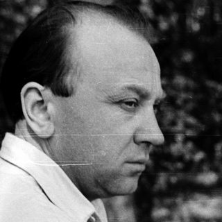 Portrait of a man in a white shirt outdoors.