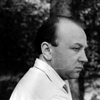 Portrait of a man in a white shirt outdoors.