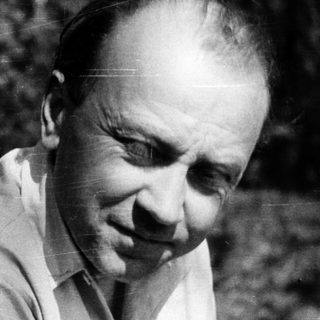 Man in outdoor setting, mid-profile, wearing light shirt.