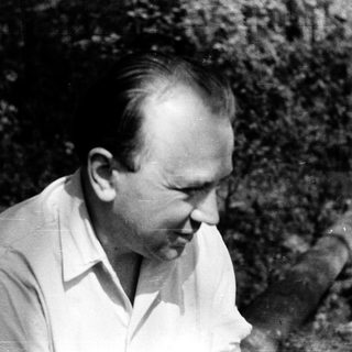 Man in outdoor setting, mid-20th century, wearing light shirt.