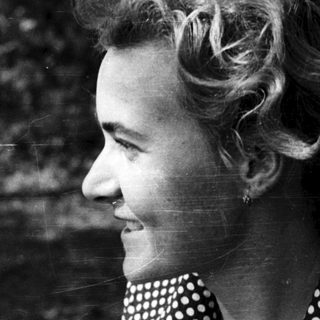 Smiling woman in polka-dot blouse outdoors.