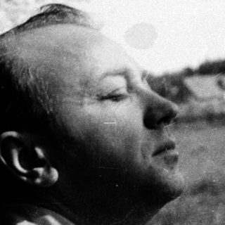 Man gazing upward in outdoor natural setting.