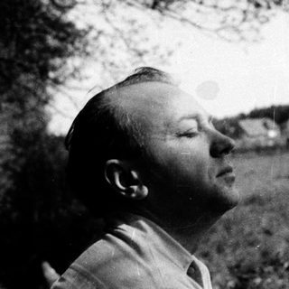 Man gazing upward in outdoor natural setting.