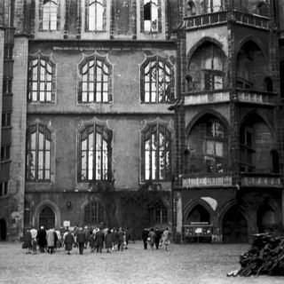 Historic Gothic-style building courtyard with people walking.