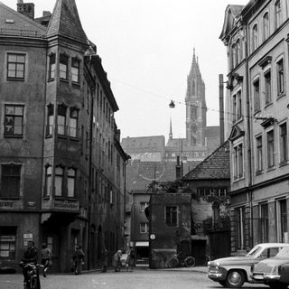 Mid-20th century European street scene with historic buildings.