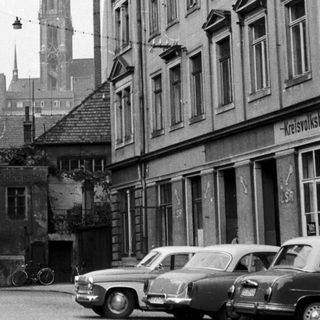Mid-20th century European street scene with historic buildings.