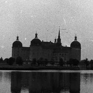 Historic castle reflected in calm water.