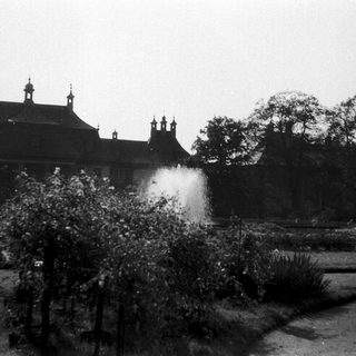 Black-and-white photo of historic building with water fountain.