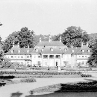 Grand historic mansion with symmetrical architecture and formal gardens.