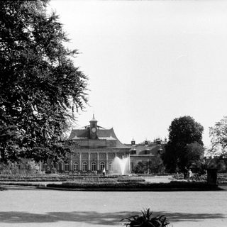 Elegant mansion with fountain in landscaped park.