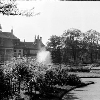 Historic mansion with formal gardens and fountain.