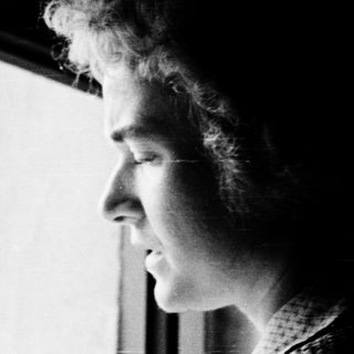 Person gazing thoughtfully outside through a window.