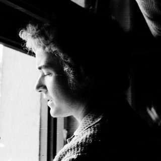 Person gazing thoughtfully outside through a window.
