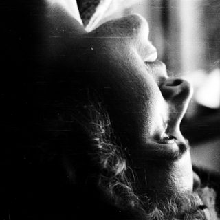 Person gazing thoughtfully through a window.