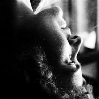 Person gazing thoughtfully through a window.