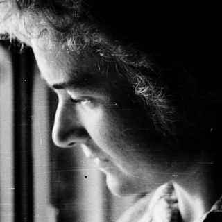 A person gazing intently through a window.