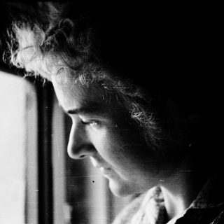 A person gazing intently through a window.