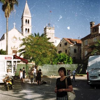 Woman standing on Mediterranean coastal town street.