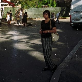 Woman standing on Mediterranean coastal town street.