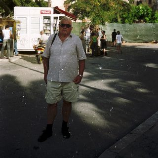 Man standing outdoors during festive water celebration.