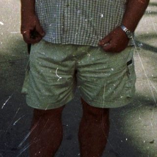 Man standing outdoors near historic church and public building.