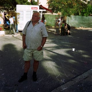Man standing outdoors near historic church and public building.