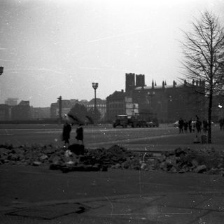 Destruction and debris in city square during wartime.