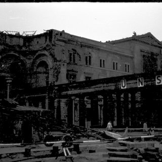 Destroyed building with "UNSEN" signage after bombing.
