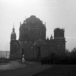 Damaged cathedral in urban setting, post-war era.