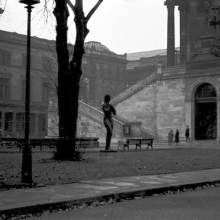 Historic building courtyard with grand staircase and lone figure.