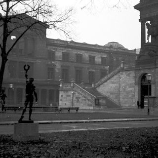 Historic building with grand staircase and statue.