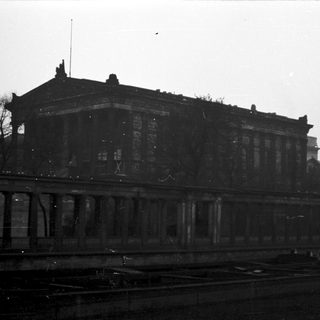 Damaged historic building near railway tracks.