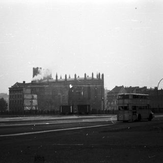 Black-and-white street scene with burning historic building.