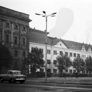 Historic urban street with vintage cars and classic architecture.