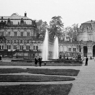 Baroque palace gardens with fountains and classical architecture.