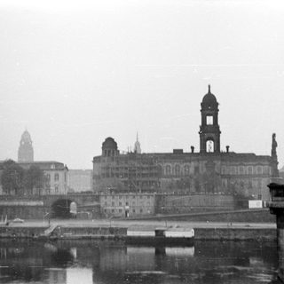 Historic cityscape with prominent cathedral and riverfront buildings.
