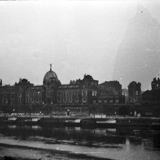Historic palace by waterfront, likely post-war damage.