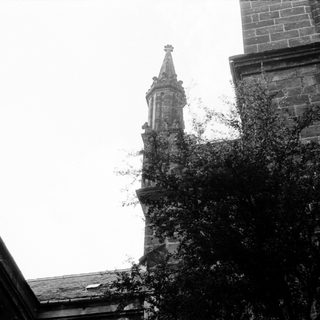 Gothic church spire with ivy-covered stone tower.
