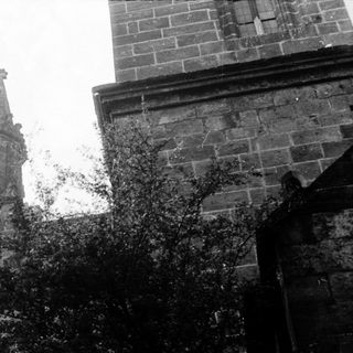 Gothic church spire with ivy-covered stone tower.