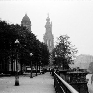 Historic city street with prominent cathedral towers.