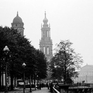 Historic city street with prominent cathedral towers.