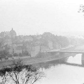 Misty cityscape with bridge and river.