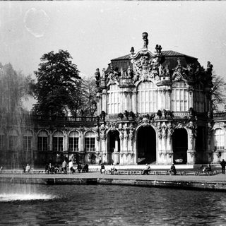 Baroque-style palace with fountain in park setting.