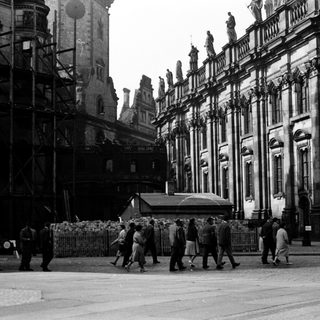 Historic building under renovation with workers and scaffolding.