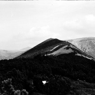 Mountain landscape with forested slopes and summit.