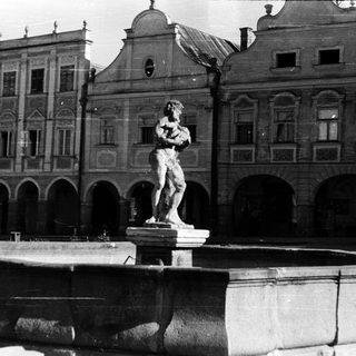 Baroque-style building with classical statue fountain.