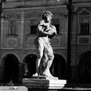 Baroque-style building with classical statue fountain.